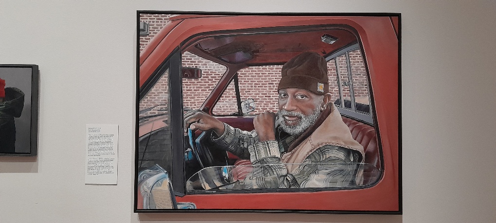 My friend as he is, portrait from the portrait awards of a black middle aged man sitting in his van his throne by S Ross Browne